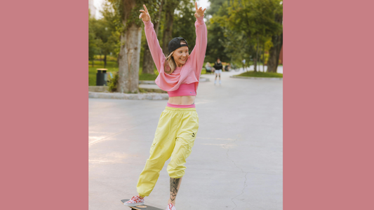 Woman on skateboard with arms in air