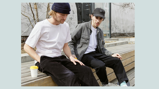 Two men on a bench in hats 