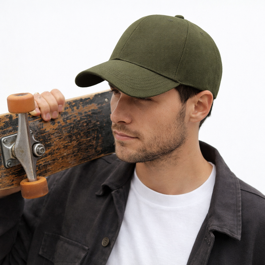 Man in olive green classic baseball cap holding skateboard