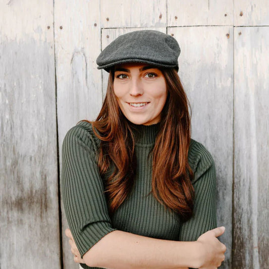 Woman in flat cap and green jumper