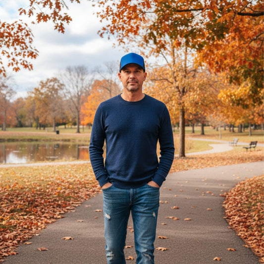 Man in autumn park wearing blue and black trucker cap 