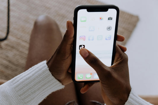 Pair of hands opening TikTok on a mobile phone