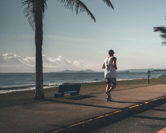 Man jogging by sea in cap 