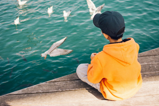 Boy with seagulls in snapback cap 