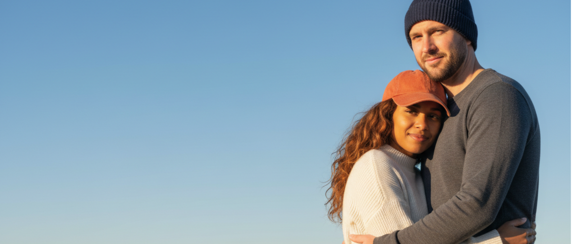 man and a woman wearing a baseball cap and a beanie hat